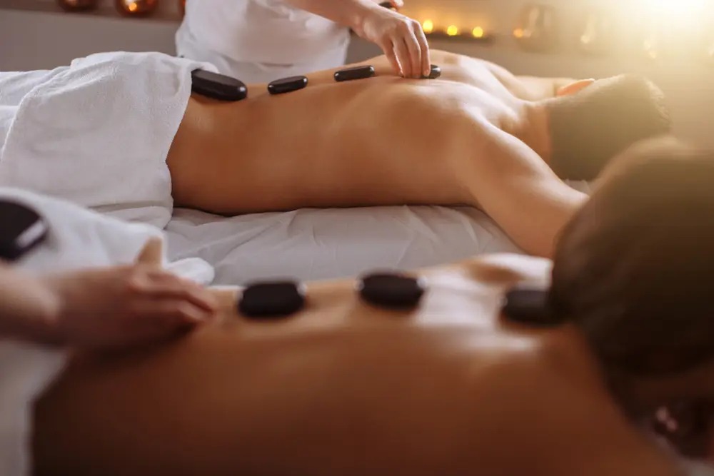 Massage Đá Nóng Chuyên Nghiệp Khách hàng đang được xoa bóp với Massage đá nóng tại spa thư giãn