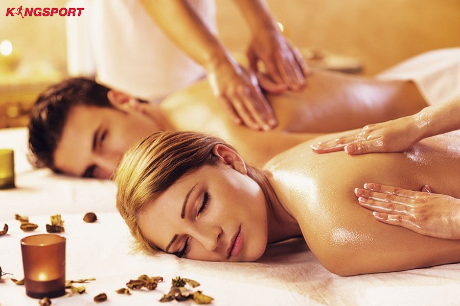 Massage Tinh Dầu Trị Liệu kỹ thuật viên spa thực hiện Massage tinh dầu trên lưng khách để thư giãn